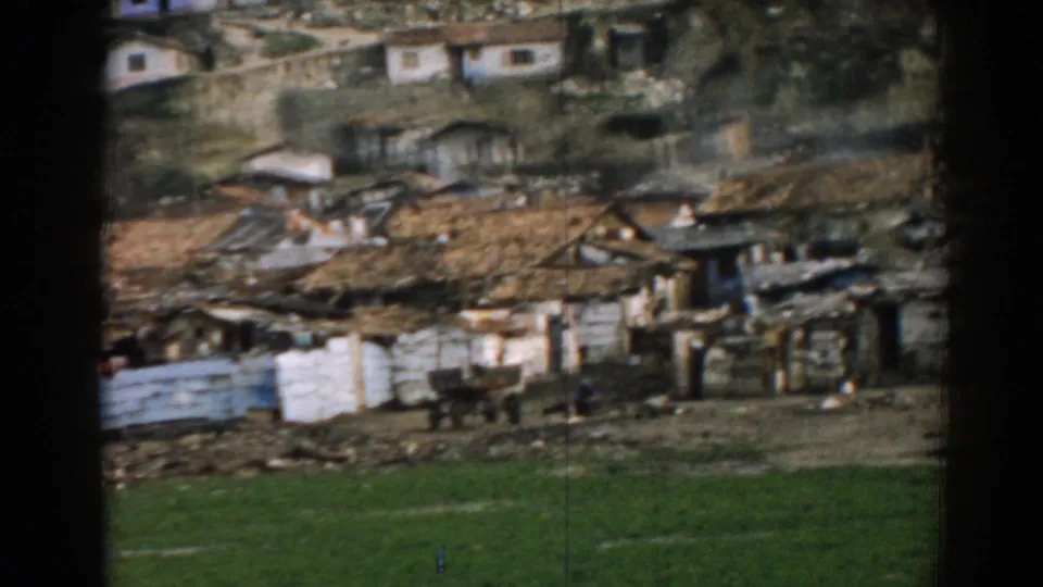 1962 Izmir frame with modest hillside dwellings, patched fencing, rough yards, and a green foreground strip.