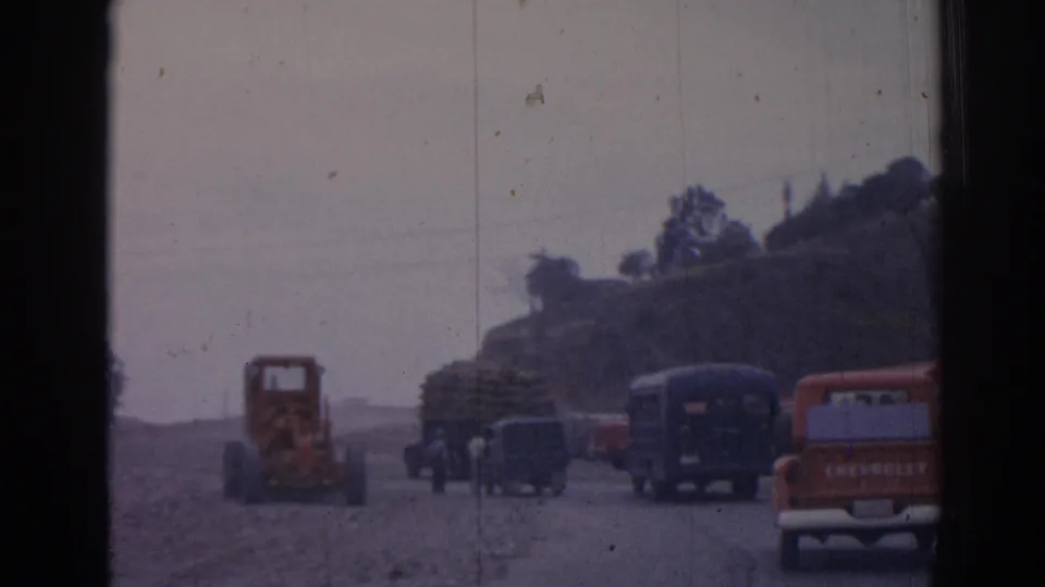 1962 Izmir roadside view with an orange tractor, dark buses, and a branded Chevrolet pickup in 8mm color footage.