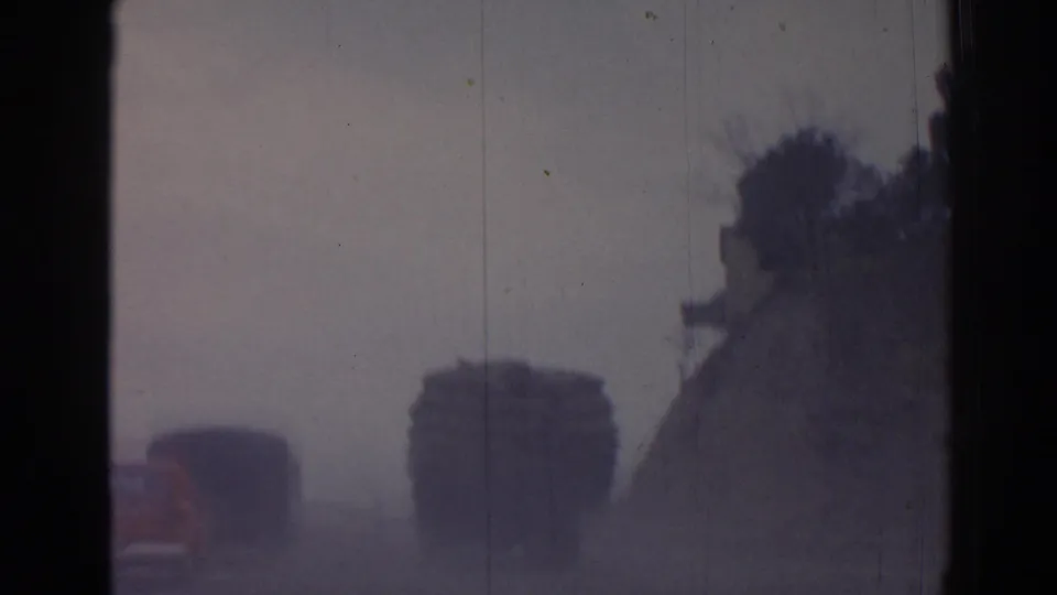 Final 1962 Izmir frame with the convoy partly distant, softened by haze, grain, and dark film edges.