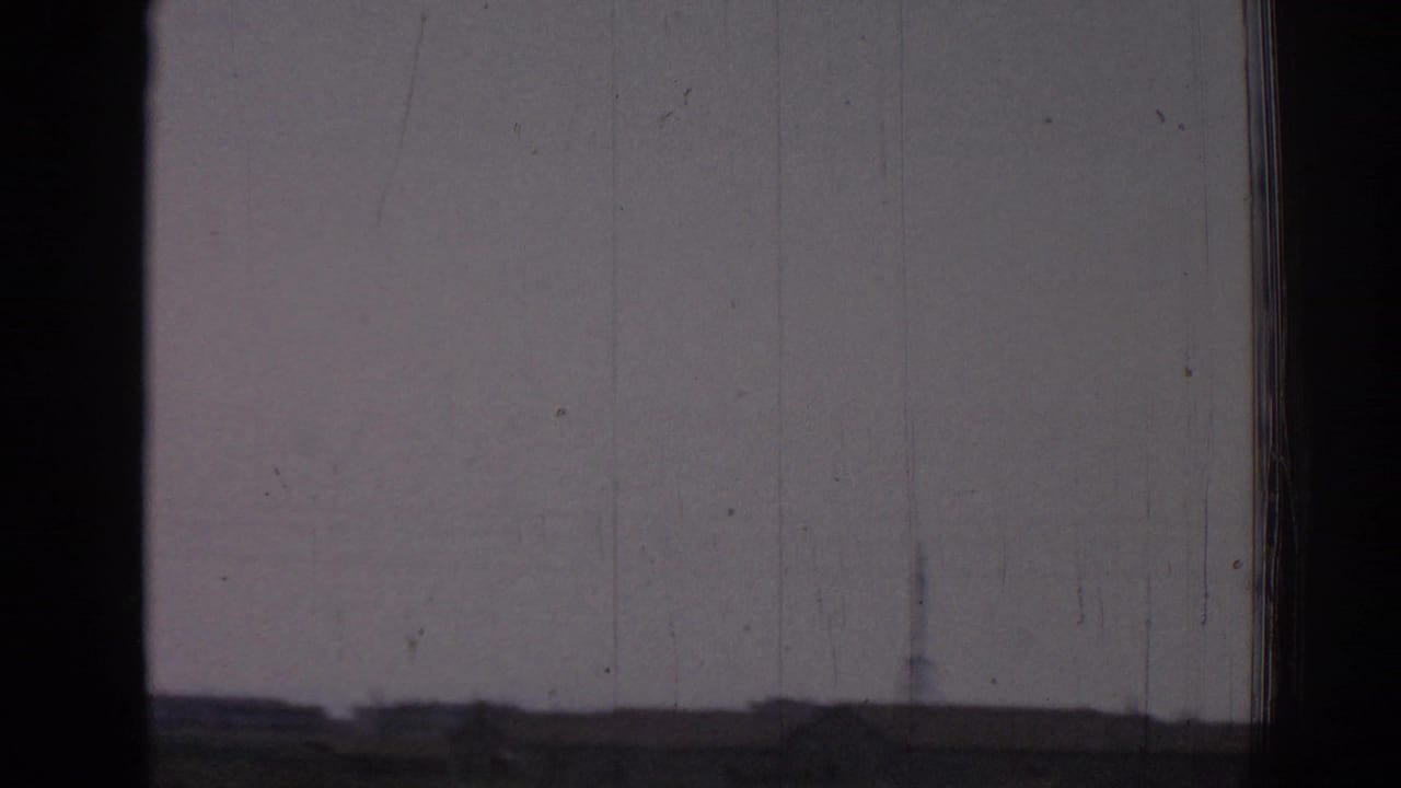 Dark window frame over a hazy exterior view with faint horizon and film scratches.