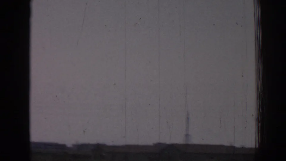 Early frame from 1962 Izmir footage showing a hazy view through a window frame with soft focus and visible 8mm wear.