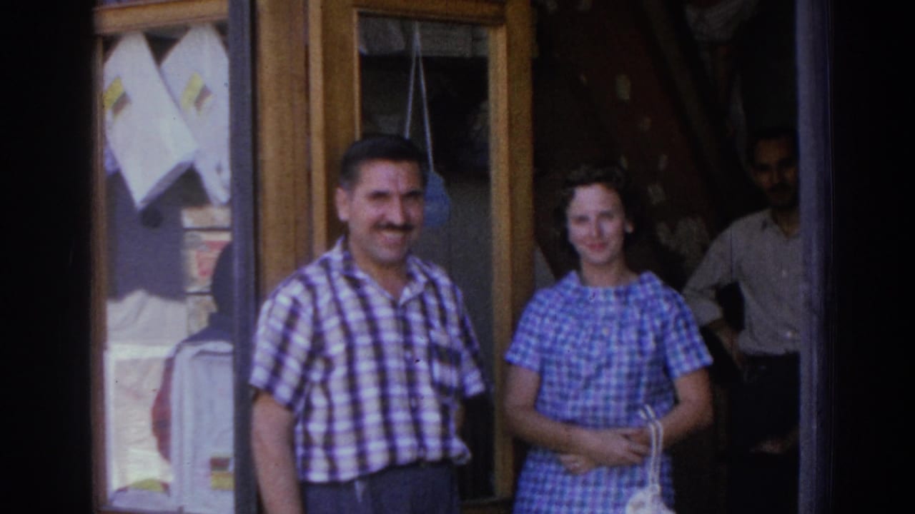 The man and woman remain near the shop doorway in Izmir, with a shadowed figure visible behind them.