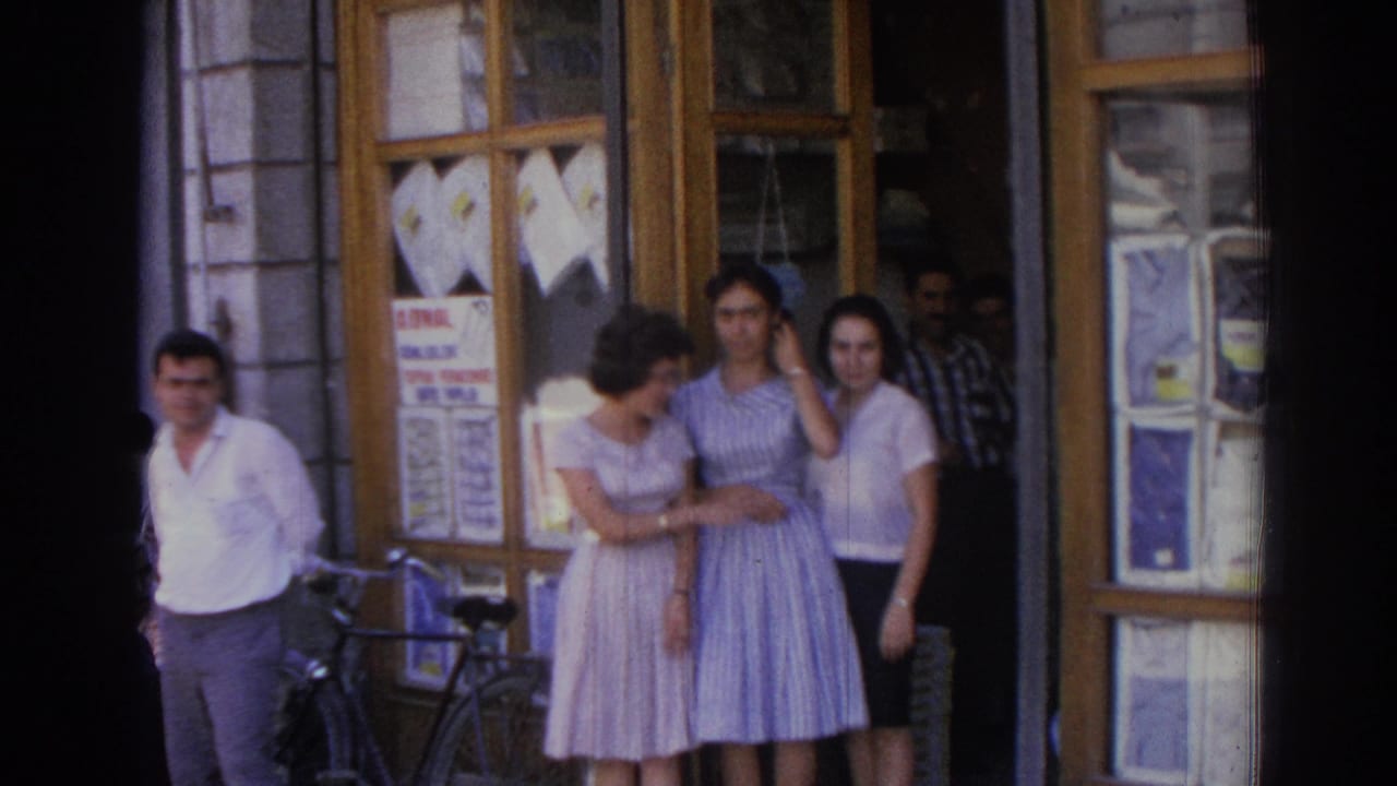 In the Izmir street scene, the women remain outside the shop while one adjusts her hair and a bicycle is parked near the doorway.
