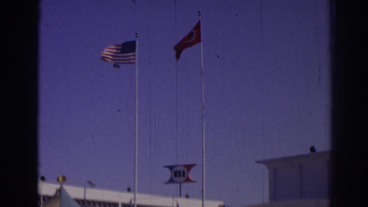 U.S. and Turkish flags near a venue roof with a USA sign visible.