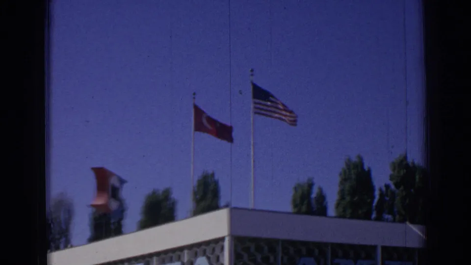 A tighter 1962 Izmir view shows Turkish and U.S. flags above the NATO facility roofline and patterned exterior wall.