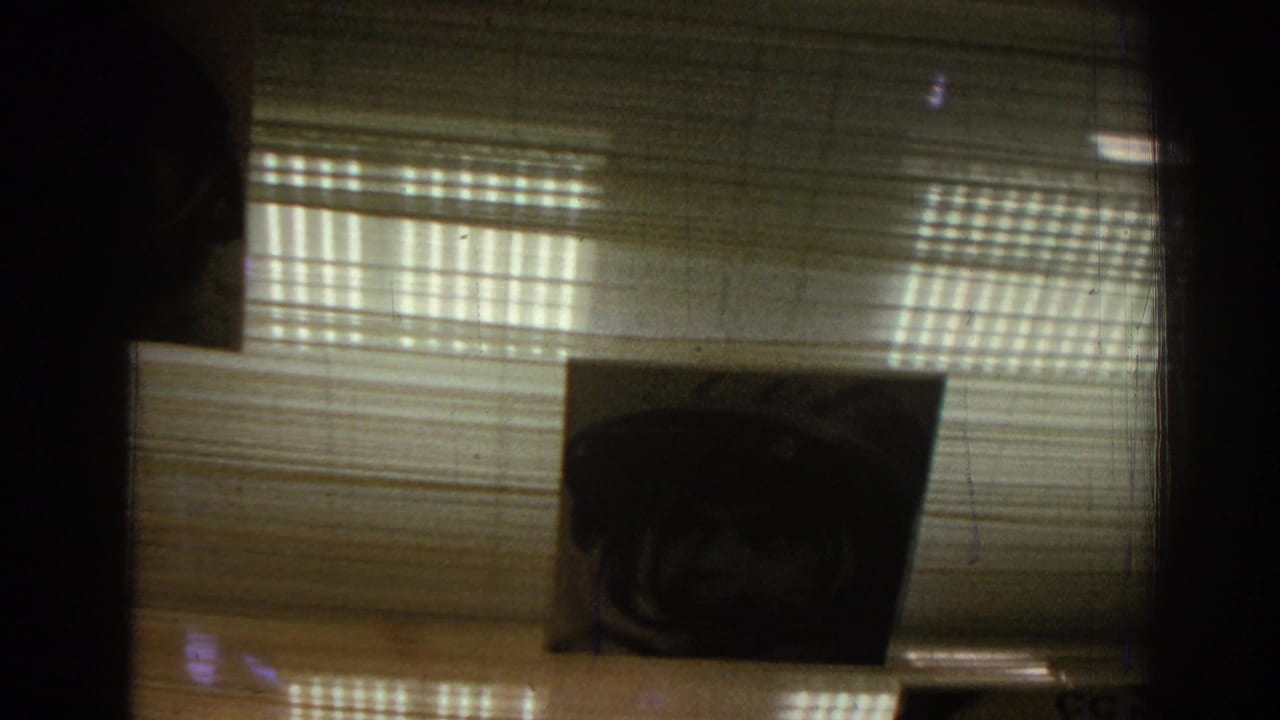 Ceiling display with a dark astronaut portrait beneath horizontal blinds and striped light.