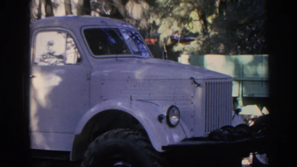 The camera frames the truck's cab, front wheel, grille, and headlamp in an outdoor Izmir setting from the 1962 footage.