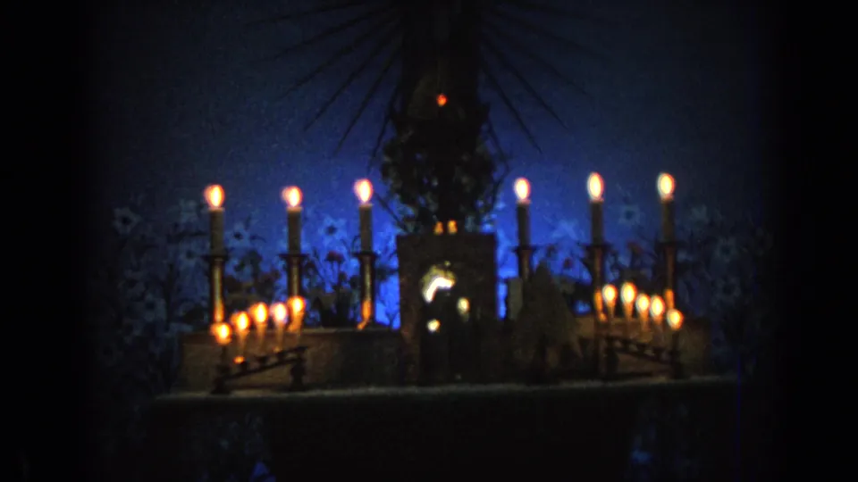 1962 Izmir church interior with a haloed religious statue silhouetted among tall candles and clustered votive lights.