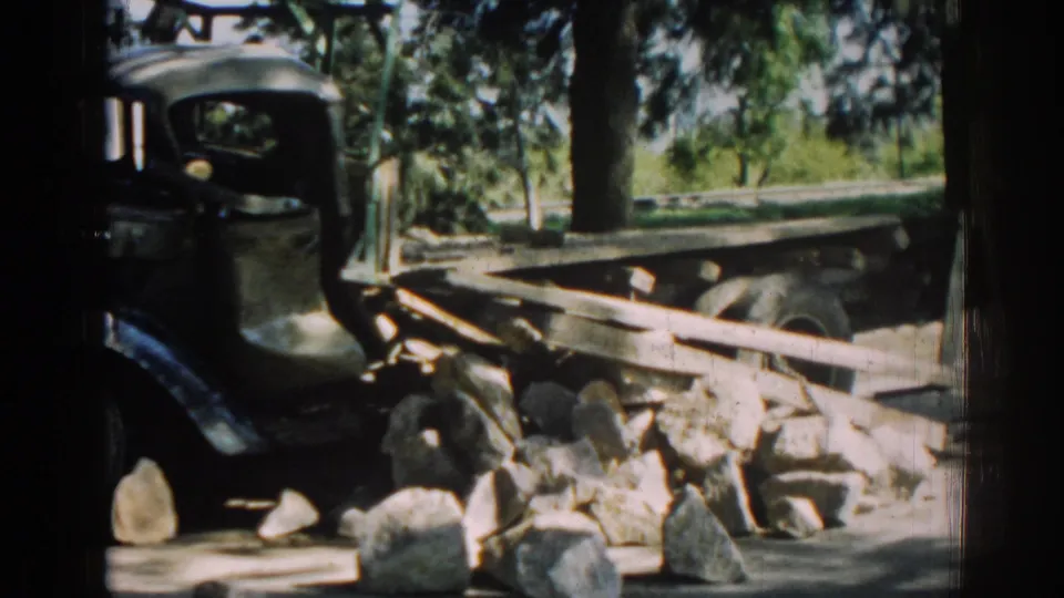 Final frame shows the green truck cab partly obscured by shadow, with a wooden flatbed, stones, and trees in the Izmir roadside setting.