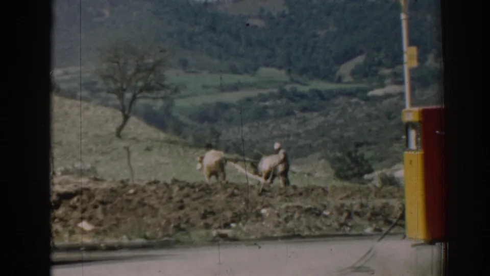 Near the end of the clip, the farmer and oxen work at the edge of the plowed field, with the roadside pump still framing the rural Izmir view.