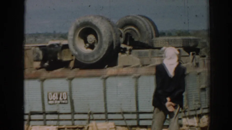 In the Izmir roadside scene, a headscarf-wearing adult stands by the overturned truck as cargo remains scattered nearby.