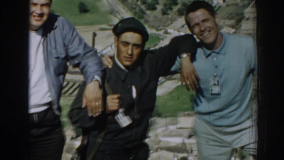 A tighter 1962 Izmir frame shows two young men and part of a third posing with rural fields below the hillside.