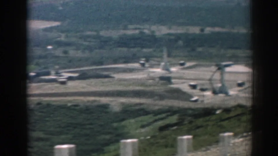 The final frame shows a soft 1962 Izmir valley view with roadside posts, open fields, distant structures, and parked vehicles.