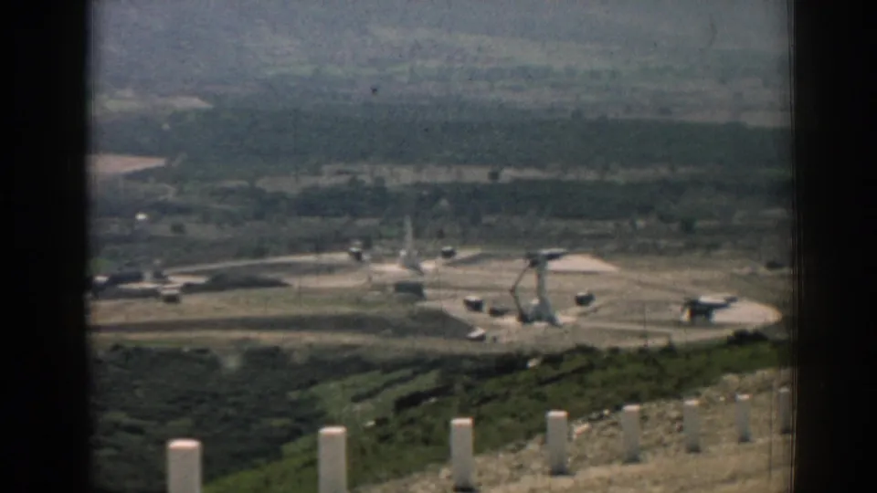 1962 Izmir footage appears to show a distant missile launch area with equipment on a concrete pad, framed by dark vertical edges.