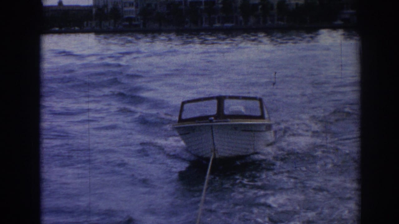 Near the end of the 1962 Izmir clip, the small motorboat is closer in frame, riding through wake against a dark waterfront backdrop.