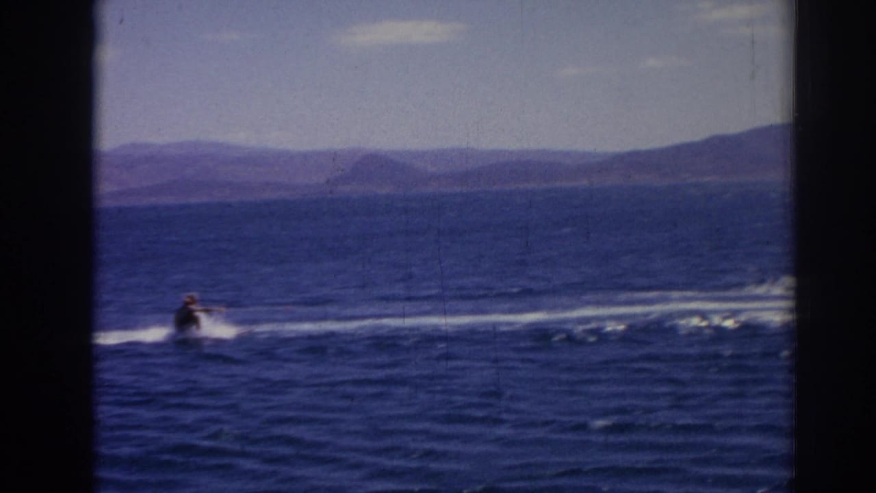 The skier appears farther from camera as the tow line and wake stretch across the blue sea near Izmir.
