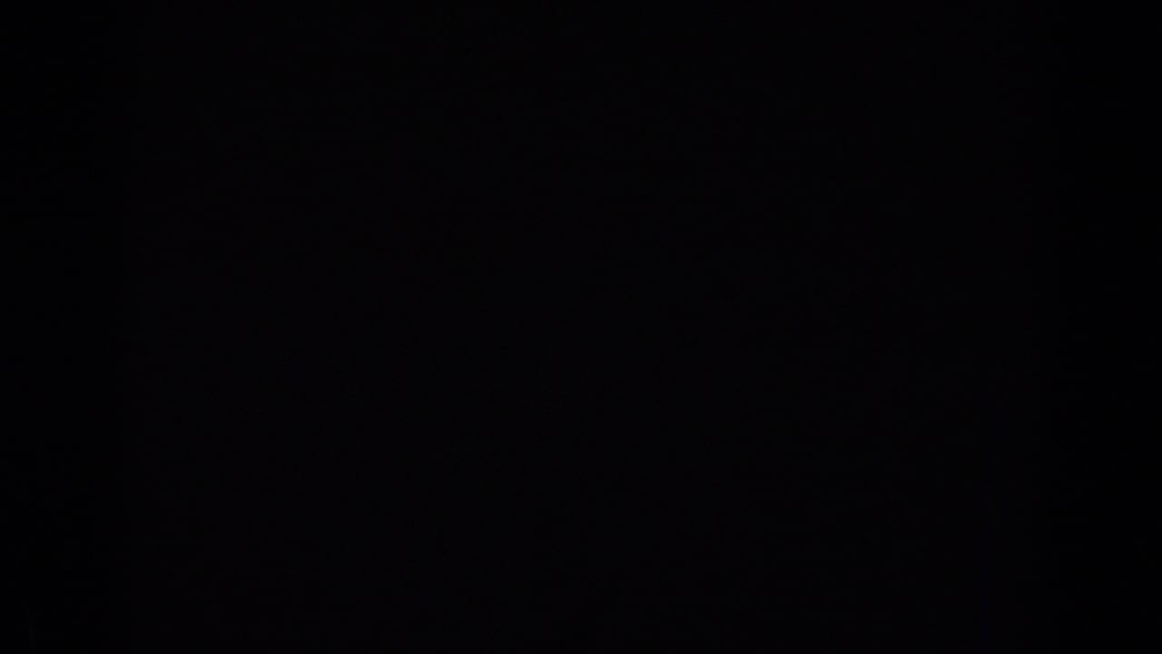 Very dark 8mm frame with minimal visible detail, likely an underexposed or blocked moment between boat and water views.