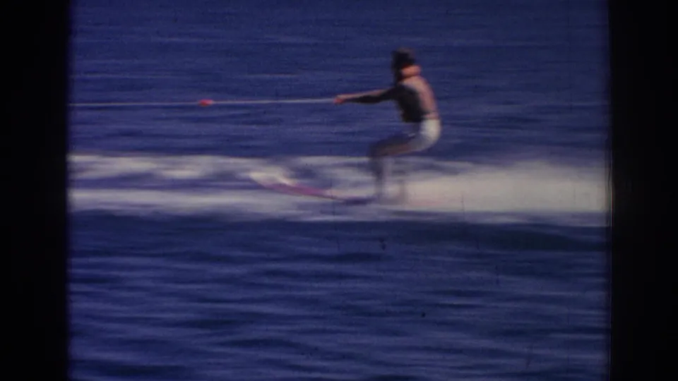 The 1962 Izmir shot shows the skier pulled by a tow rope, with motion blur, white spray, and open water filling the frame.