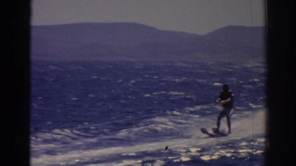 The water skier remains upright on the wake, holding a tow rope as the boat camera looks back across open water near Izmir.