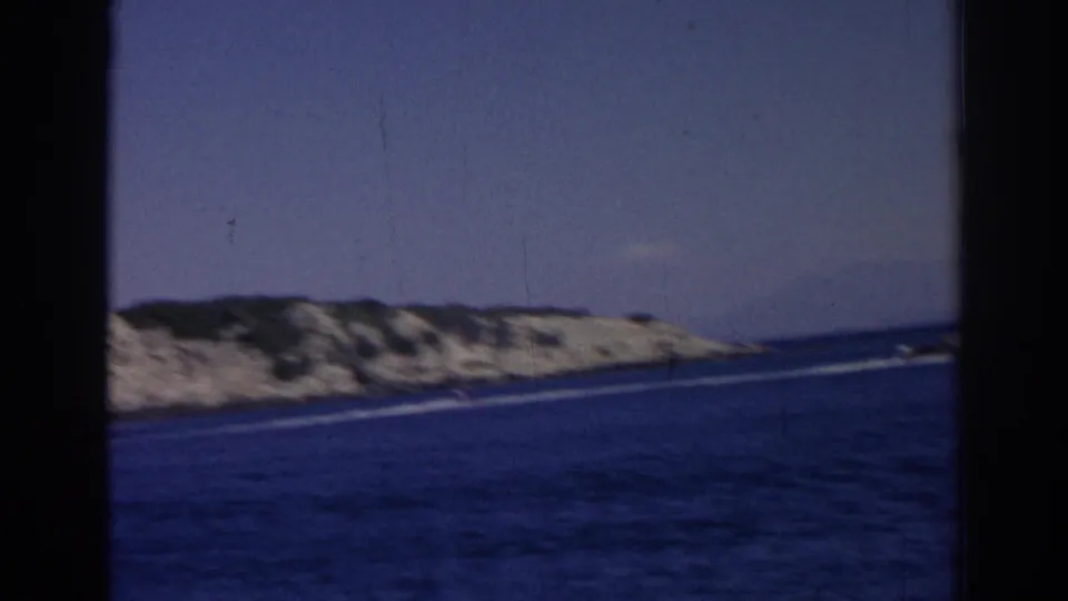 The final frame shows open blue water and a low rocky coastline, with no clear rider visible in the shot.