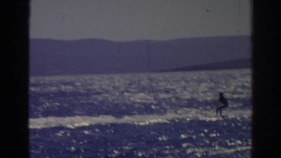 Distant water skier in the 1962 Izmir footage glides near the right side of the frame with a long wake behind.