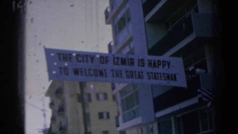 1962 Izmir street banner stretched near apartment buildings, welcoming a great statesman in bold lettering.