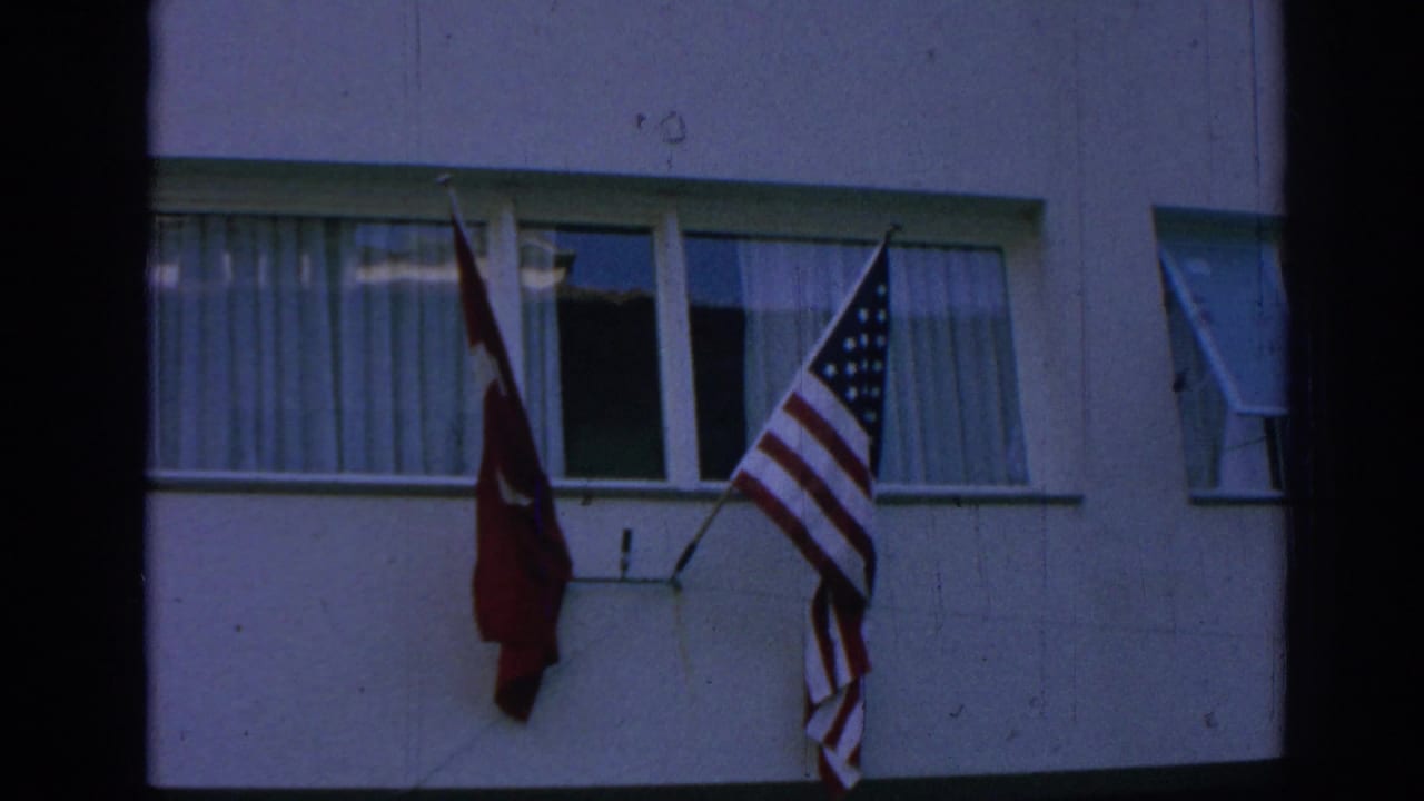 Turkish and U.S. flags hang side by side from a window on a building facade in Izmir, Turkey.