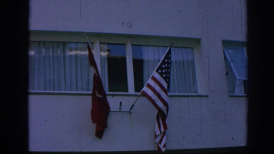 Turkish and U.S. flags hang side by side from a window on a building facade in Izmir, Turkey.