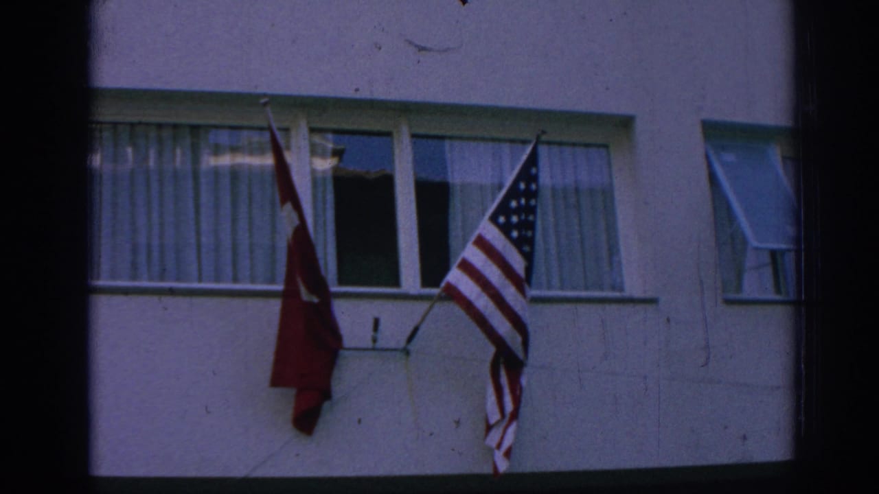 A second close frame shows Turkish and U.S. flags side by side on the building, with curtains visible behind the glass.
