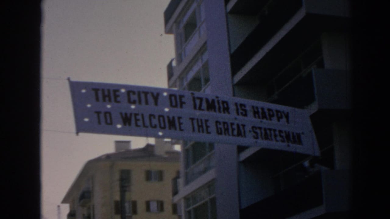 A suspended Izmir welcome banner is more legible as it hangs beside apartment balconies in the 1962 footage.