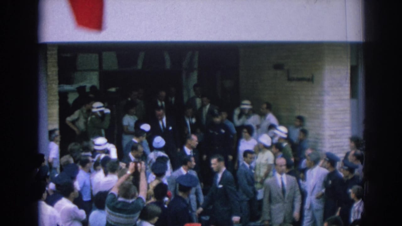 In Izmir, Turkey, 1962, photographers, officials, and police gather at a building entrance during a public arrival.