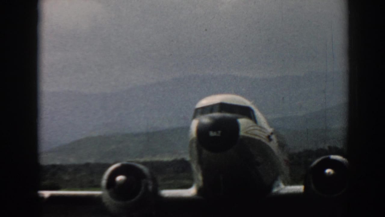 Closer 1962 Izmir view of the airliner's nose, engines, and wing, with the runway and hazy hills behind it.