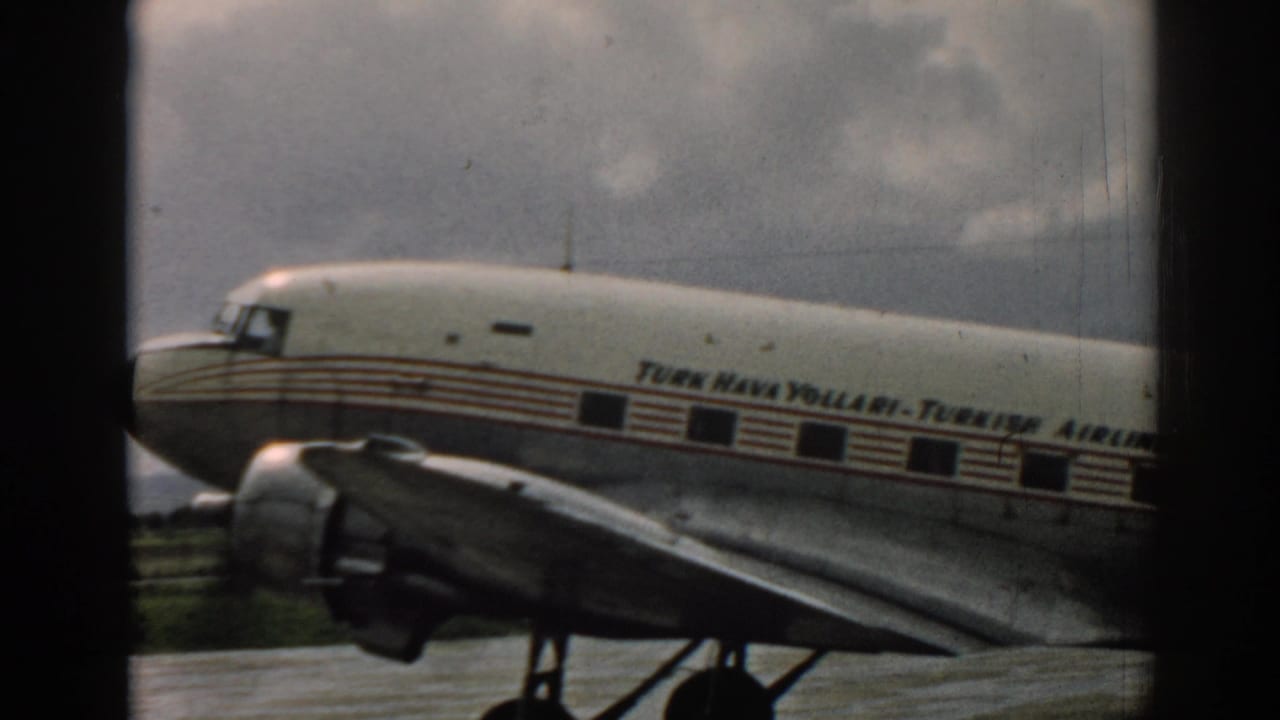 Turkish Airlines propeller aircraft fuselage and wing seen through a dark window frame.