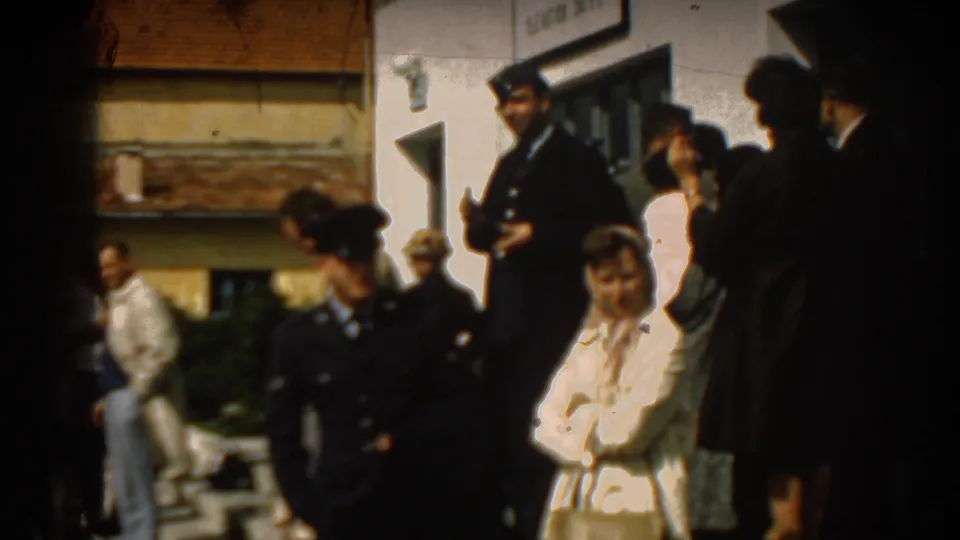 People gather near an Izmir airport building in 1962, including uniformed men and civilians watching an arrival.
