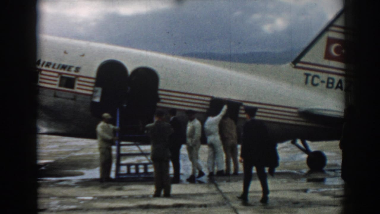1962 Izmir airport scene with men in white uniforms boarding a Turkish Airlines plane via portable stairs.