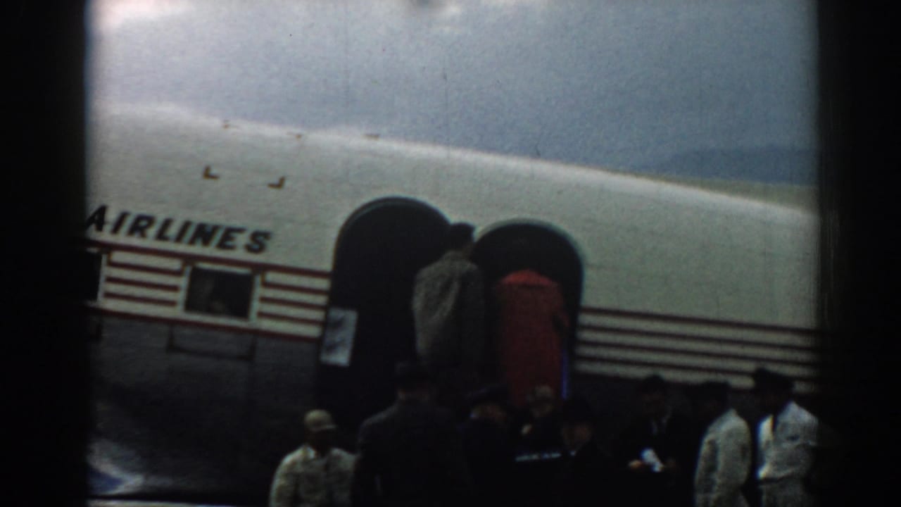 Travelers board a white aircraft through stairs attached to the fuselage.