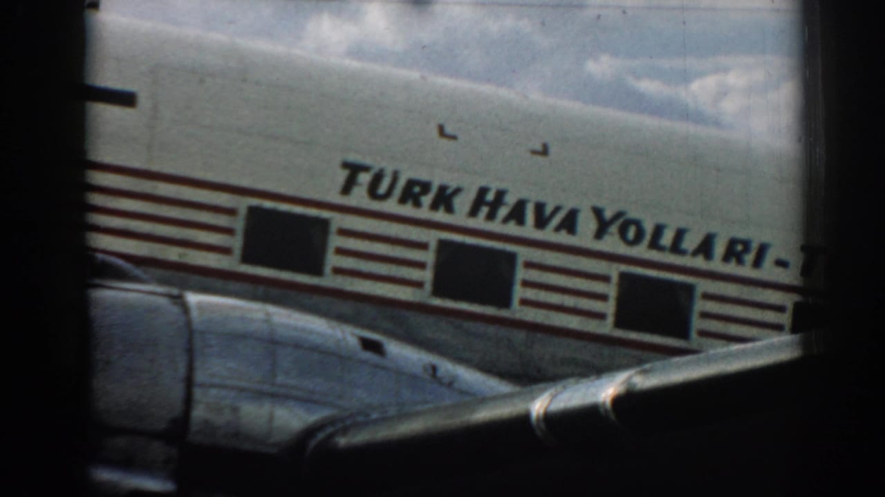 Turkish Airlines aircraft fuselage seen through a dark window frame.