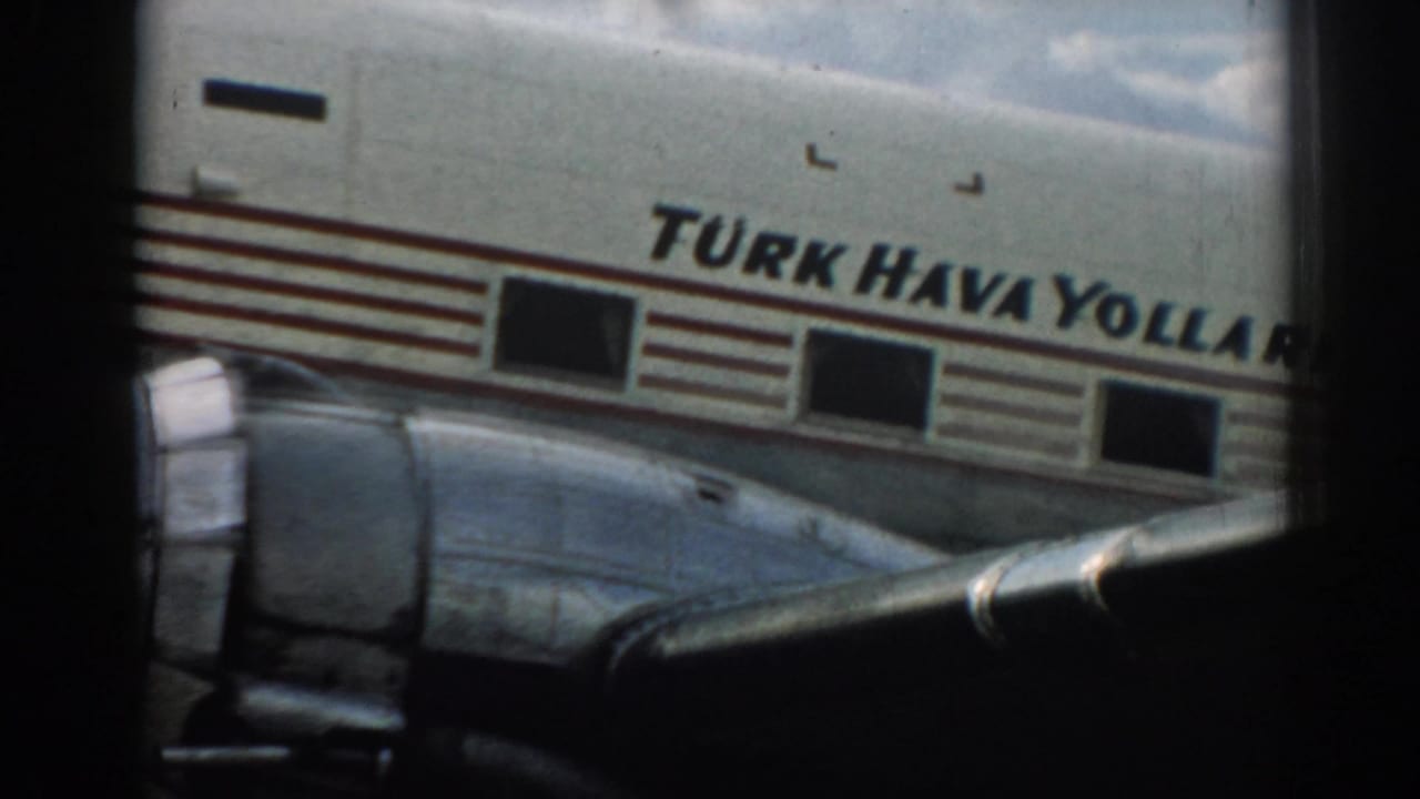 Close view of Turkish Airlines lettering and aircraft windows behind a window frame.