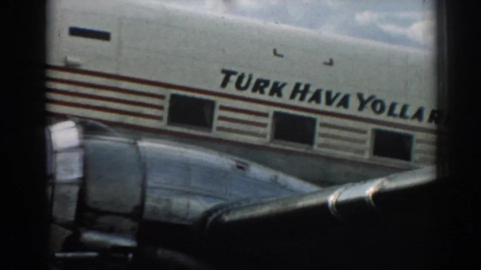 The Turkish Airlines name appears across the fuselage, with red striping, square windows, and part of the wing visible from a passenger-window perspective.