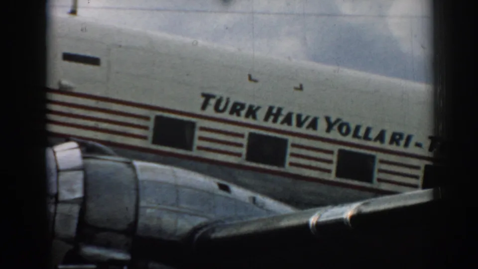 Tight 1962 Izmir view of a Turkish Airlines propeller aircraft side, with fuselage lettering, windows, engine, and wing visible.