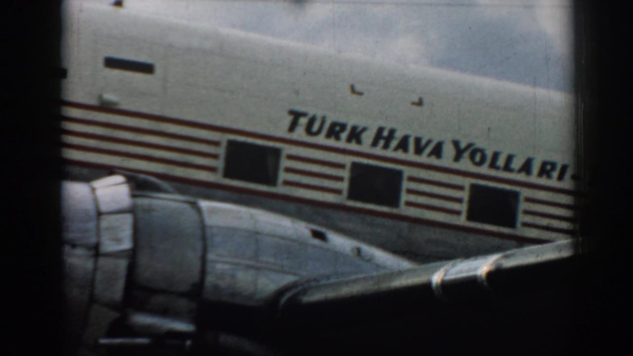 Close view of a Turk Hava Yollari aircraft fuselage and wing seen through a dark frame.