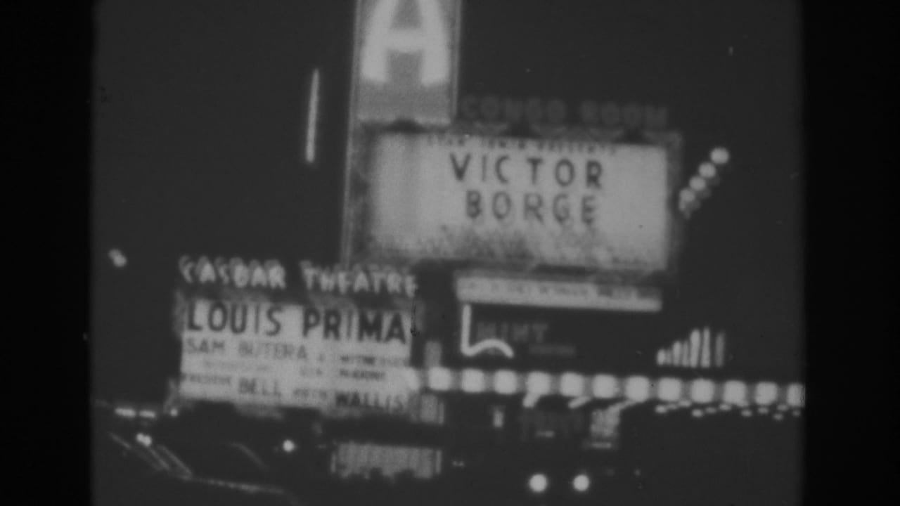 1962 Las Vegas home-movie frame showing marquee signage for Victor Borge and Louis Prima amid glowing theater lights.