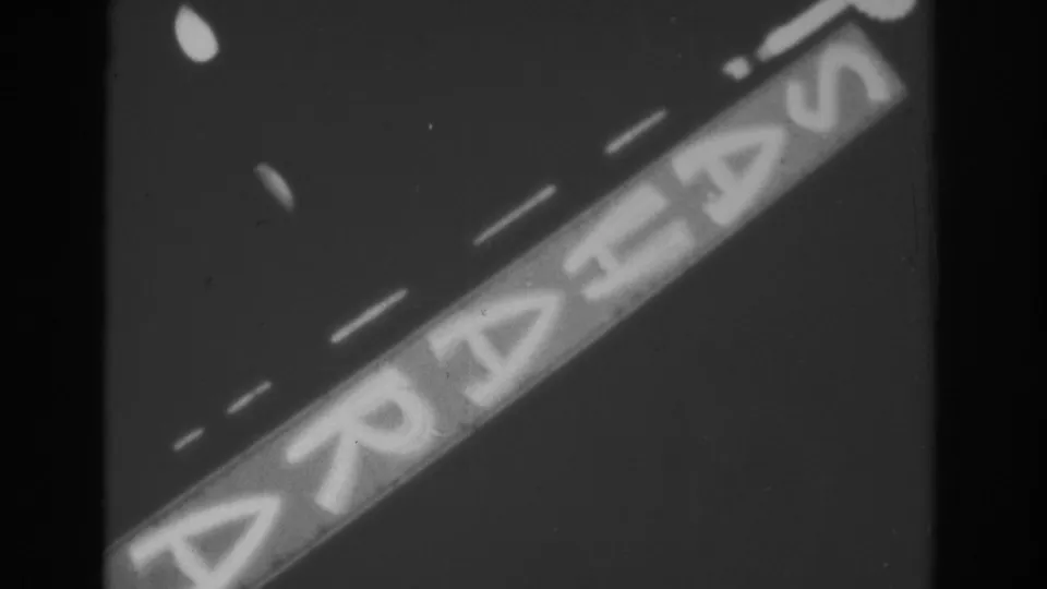 The Sahara sign remains angled through the 1962 Las Vegas night frame, with pronounced 8mm grain and soft exposure.