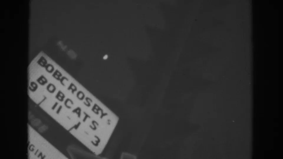 Final 8mm frame shows a partial film leader label with handwritten and printed text beside the dark field.