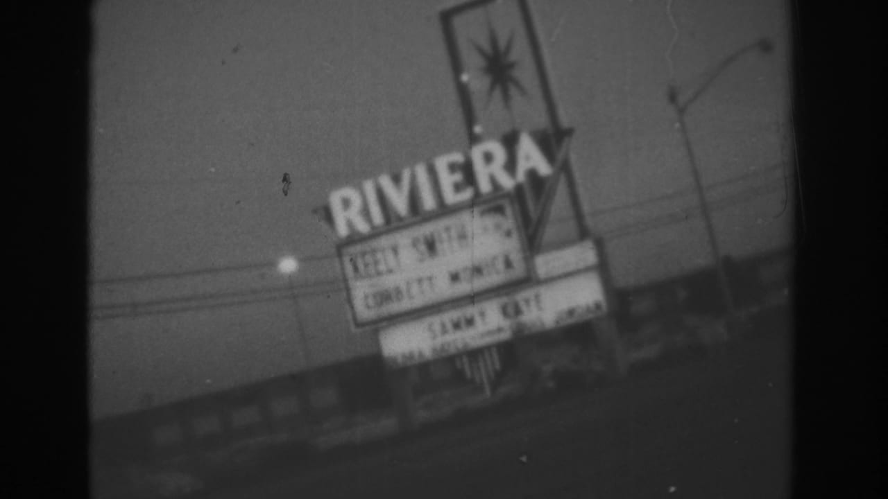 Handheld 1962 Las Vegas view of the Riviera sign, marquee lettering, roadside lights, and overhead lines at night.