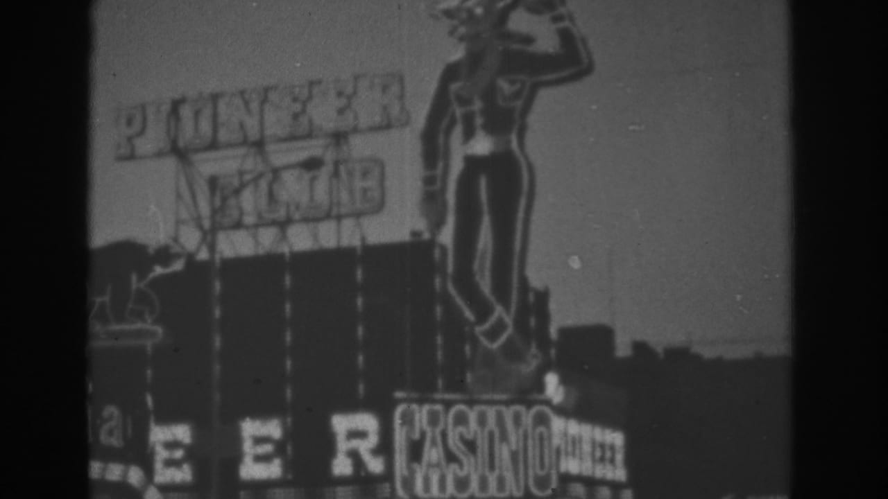 Pioneer Club sign with illuminated cowboy figure above a casino marquee at dusk or evening.