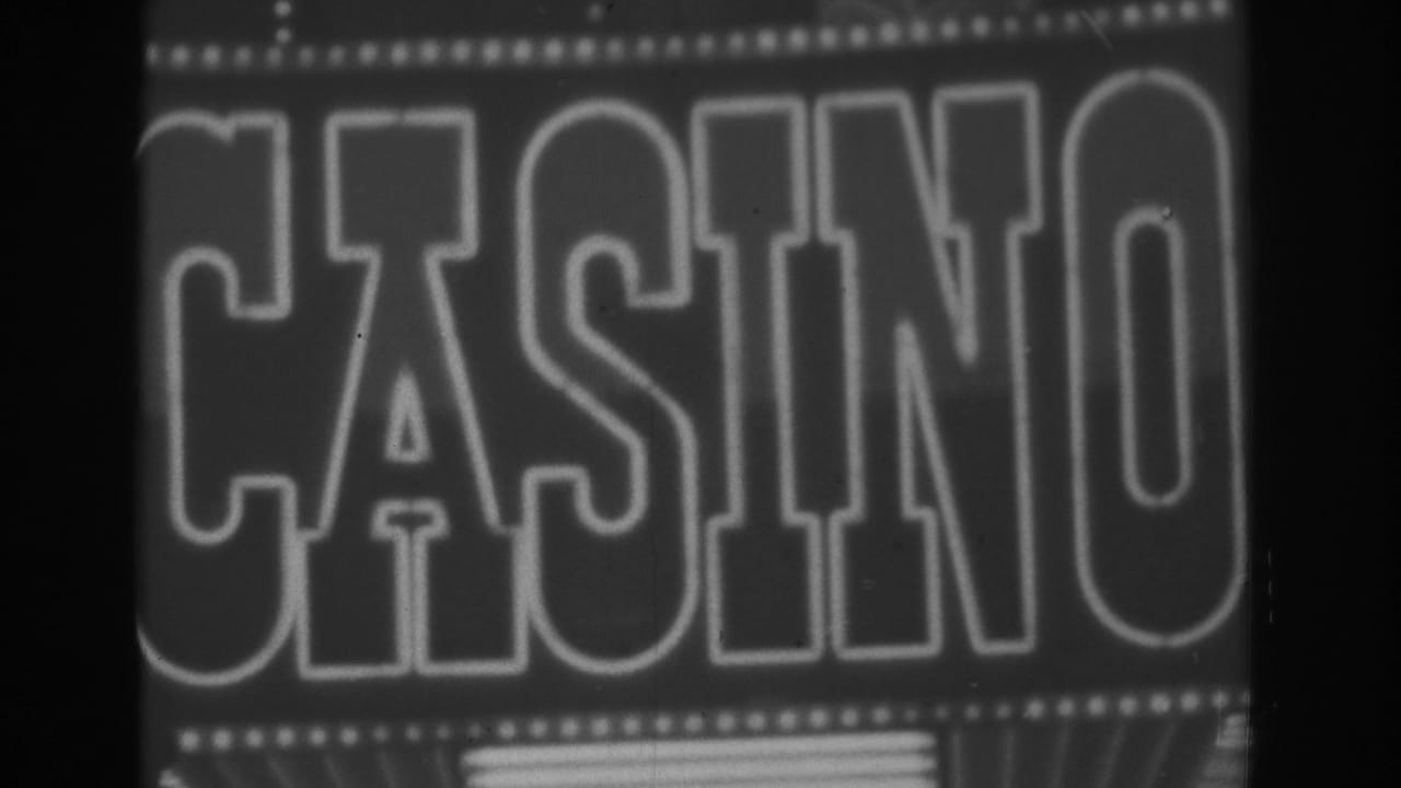 Close view of a Las Vegas casino sign in 1962, with oversized CASINO lettering and rows of bulbs on black-and-white 8mm film.
