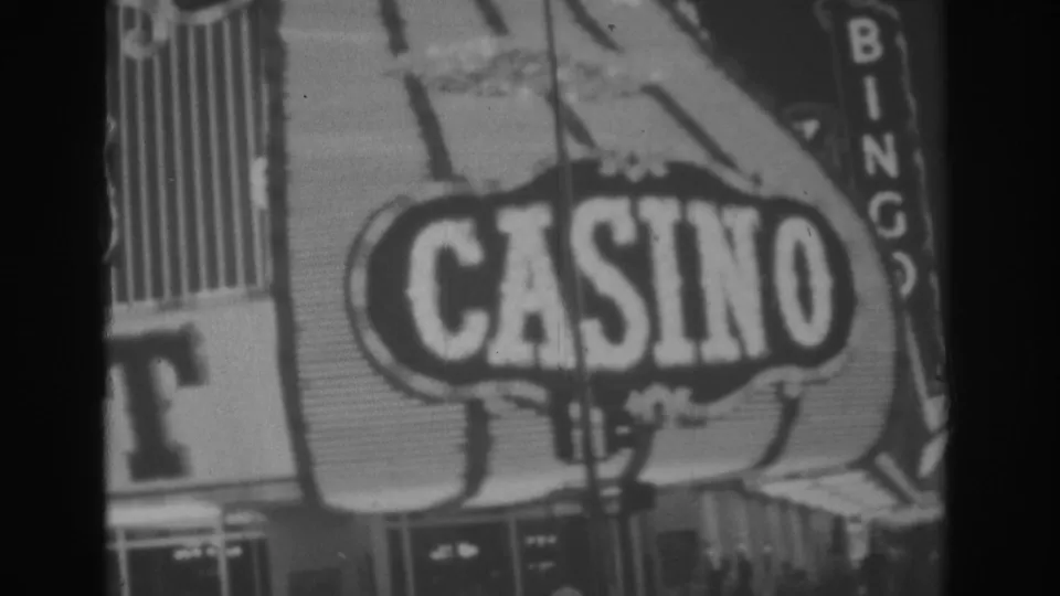 Las Vegas casino frontage with a large CASINO sign and vertical BINGO sign, filmed at night in 1962.