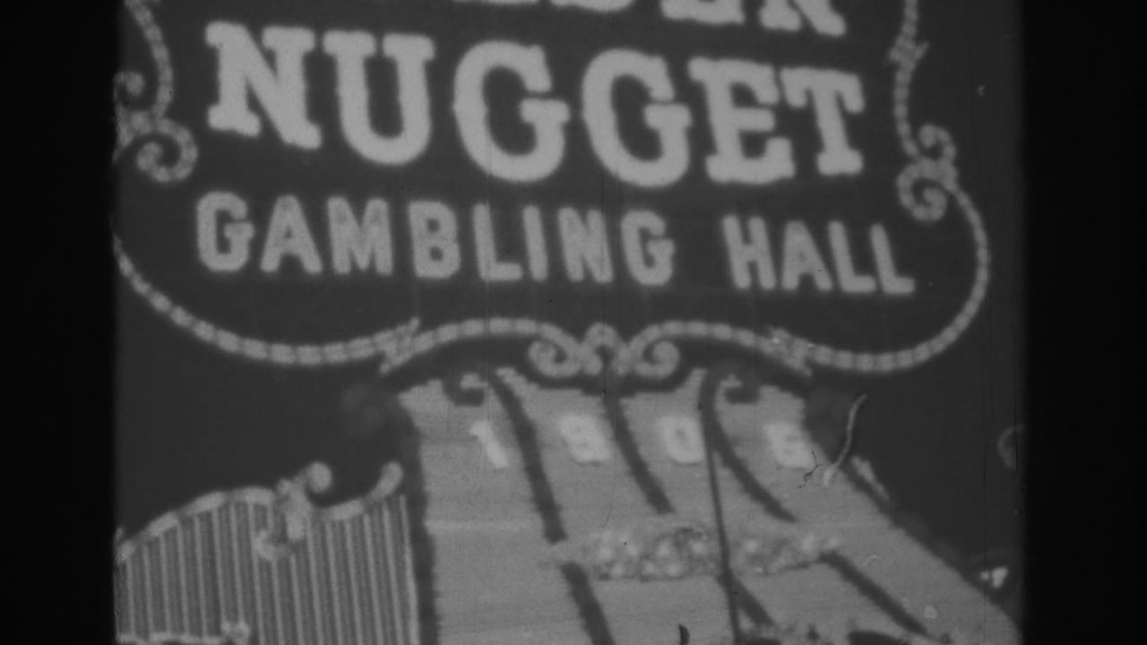 Black-and-white 1962 Las Vegas frame showing the Gold Nugget Gambling Hall sign with bold letters and illuminated border trim.