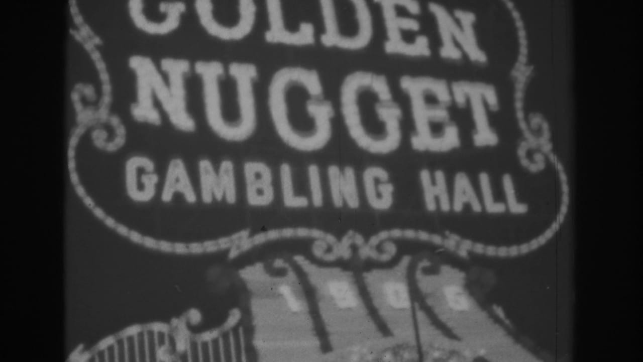 Black-and-white 1962 Las Vegas home-movie frame showing a cropped illuminated Golden Nugget Gambling Hall sign with decorative border details.